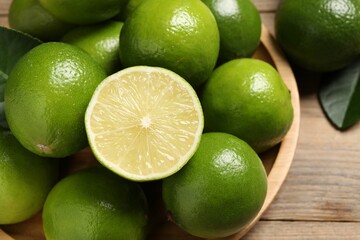 Whole and cut fresh limes on table, closeup