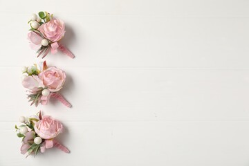 Beautiful boutonnieres on white background, flat lay. Space for text - obrazy, fototapety, plakaty