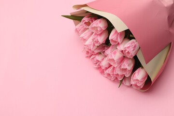 Beautiful bouquet of fresh tulips on pink background. Space for text