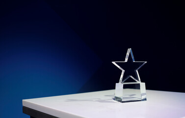 Star-shaped award on a table with spotlights and copy space