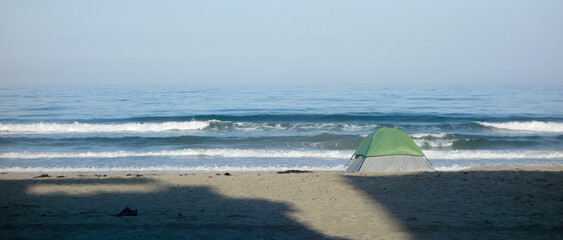 Long morning shadows across Mission beach sand reaching toward ocean waves, San Diego, CA