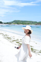 Fototapeta na wymiar an Asian girl is enjoying a holiday on the beautiful Lombok beach with a tropical climate