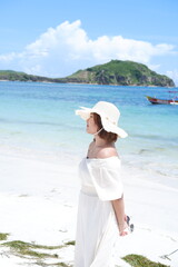 Fototapeta na wymiar an Asian girl is enjoying a holiday on the beautiful Lombok beach with a tropical climate