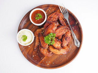 Cooked grilled chicken wings marinated with seasonings Placed on an old wooden tray on a white background
