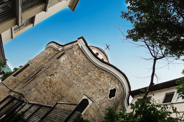 Old brick building. Church of Saints Constantine and Helena from a narrow street in the medieval town of Veliko Tarnovo in Bulgaria. The concept of tourism and travel. Dutch angle