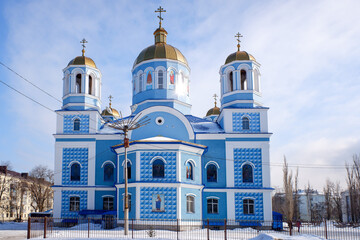 Fototapeta na wymiar Orthodox church in the forest in winter against the background of a blue sky in sunny weather