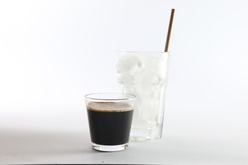 Coffee and ice cubes in different glasses on white background