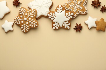 Fototapeta na wymiar Tasty Christmas cookies with icing and anise stars on beige background, flat lay. Space for text