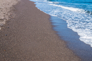 volcanic black sand beach on santorini island in greece and aegean sea	
