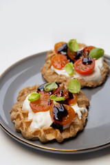 Homemade Belgian cauliflower waffles. waffles are decorated with natural yogurt, cherry tomatoes, basil leaf, presented on a plate for a healthy breakfast.	  