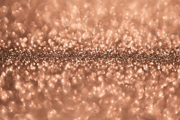 Peach fuzz sparkling glitter bokeh background, abstract defocused texture. Holiday lights. Color of the year 2024