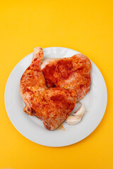 Raw chicken legs with spices on plate