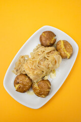 Traditional portuguese cousine, cod fish with potatoes and onions, covered with oil.