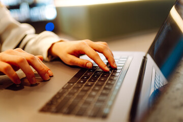 Close-up of hands working on a laptop keyboard. Young woman using laptop computer. Freelance, online course. Shopping online. Cyber security concept