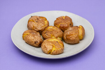 Tasty pieces of baked potatoes and salt and oil on plate