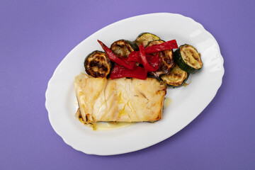 Fish dish - fried cod fish with grilled vegetables in plate