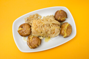 Tasty pieces of baked potatoes and salt and oil on plate