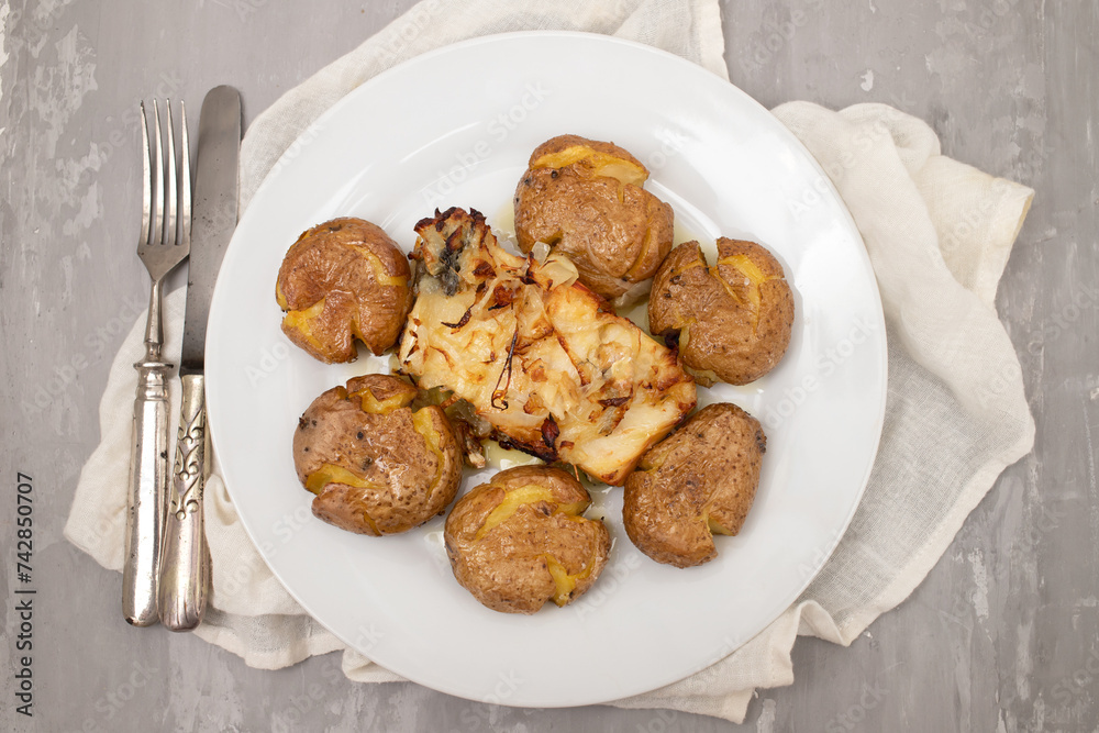 Wall mural traditional portuguese cousine, cod fish with potatoes and onions, covered with oil.