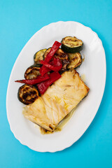 Fish dish - fried cod fish with grilled vegetables in plate