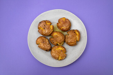 Tasty pieces of baked potatoes and salt and oil on plate