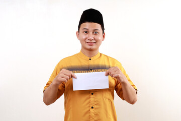 Young Asian muslim man holding an envelope filled with money. Give THR or Zakat Fitrah as an obligation in the holy month of Ramadan.