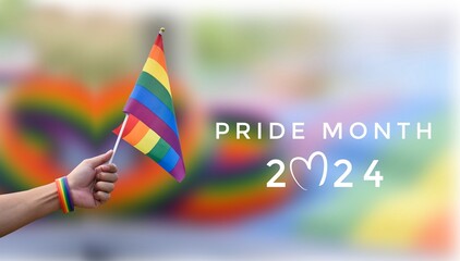 Pride Month 2024 and rainbow flag raising on blurred rainbow flags and wristband background,...