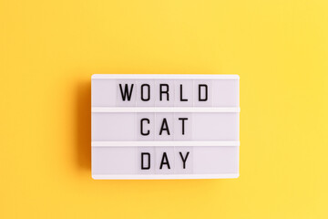 World cat day. White lightbox with letters on a yellow background.