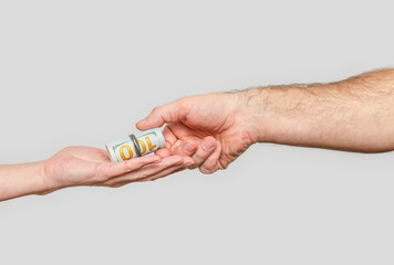 Transmission dollars from hand to hand, gray background. Concept of investment, donatons, charity.