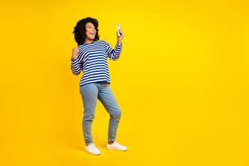 Photo of attractive charming girl wear stylish clothes recording video live stream yes hooray empty space isolated yellow color background