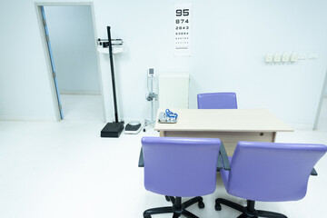 Interior of empty physician office with desk and chairs.Modern and bright doctor office with copy space.Medical tools at doctor working table.