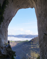 Aitzulo Cave. Hiker in the eyes of Aitzulo located in the Natural Park of Aratz-Aizkorri, Euskadi.