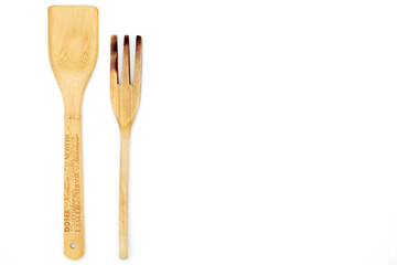 Wooden spoon and spatula for cooking, on the left side, isolated on white background, with copy space on the right. Kitchen objects for recipe preparation concept.