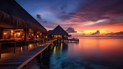 Poster Maldives at a resort on the island at sunset. © Wararat