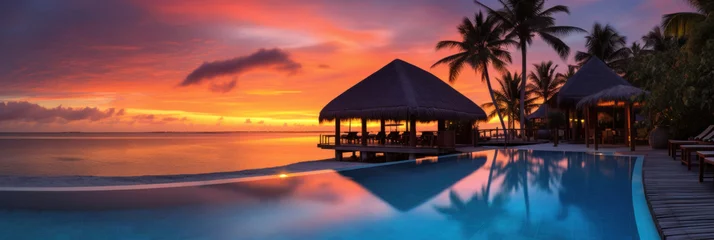 Poster Maldives at a resort on the island at sunset. © Wararat