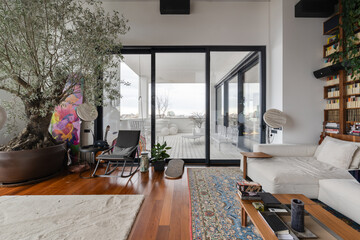 a living room with a couch , chair , table , rug and sliding glass doors