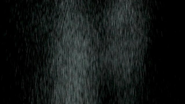 White sand falling on black background slow motion.