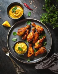 Fotobehang Exotische Chicken Wings mit aromatischer Curry-Kokos-Sauce und fruchtigem Mango-Dip © Tribar