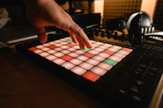 Close-up of a copper controller on a wooden desktop, male hands pressing white, green and red keys on it
