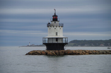 Fototapeta premium New England lighthouse and seascape ocean landscape nature view in Portland, Maine bay with horizon scenic coastal scenery