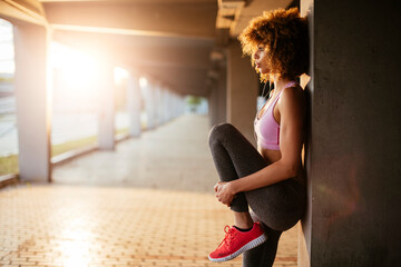 Young woman stretching before exercising and jogging in a parking lot