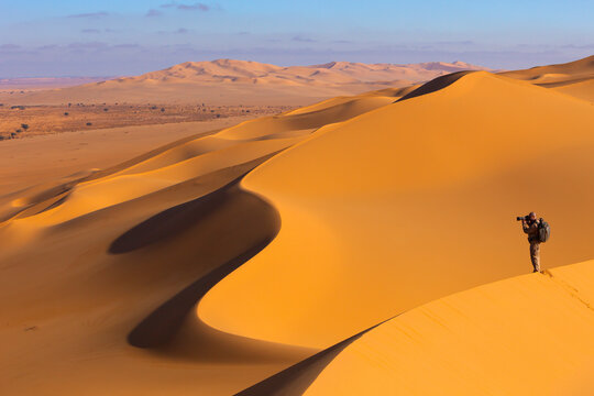 View of people on the desert sand dunes at sunset near Ghat, Sahara desert, Libya.