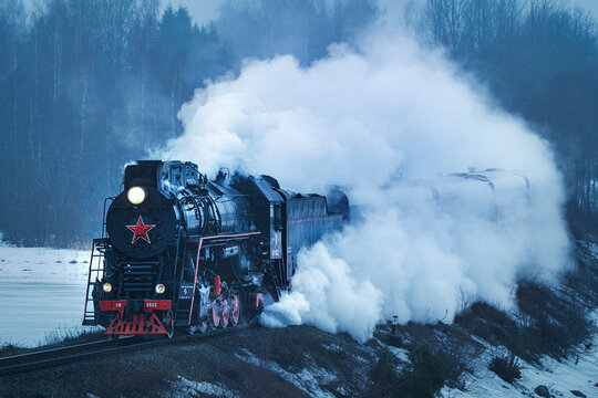 View of a steam locomotive train crossing the forest in winter, Ruskeala Express, Republic of Karelia, Russia.
