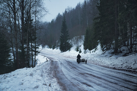 View of a person riding a sidecar motorbike on the snow in winter, Republic of Karelia, Russia.