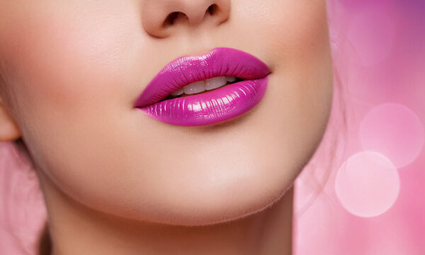 A captivating close-up of a woman’s lips, painted with a vibrant shade of pink lipstick. The image exudes femininity and elegance, capturing the allure of beauty and makeup.