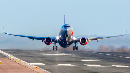 Landing at EMA G-JZBL photographed from the end of the runway in the sun.