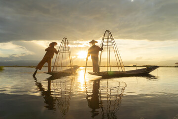 Burmese fisherman casting or throwing a net for catching freshwater fish in Unle lake, natural...