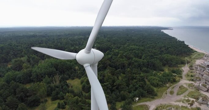 Aerial drone close-up shot of wind turbine and abandoned 19th century coastal defence battery Karosta Northern Fort, Liepāja, Latvia