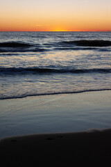 serene sunset beach, orange sky, and calming ocean waves - 742974149