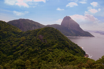 Obraz premium Sugar Loaf Mountain seen from the Leme neighborhood of Rio de Janeiro. Lush vegetation of the Atlantic Forest, blue sky and sea make up the scene