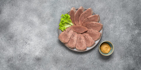 Pieces of boiled beef tongue on a plate with mustard, gray background. Top view, flat lay, copy space. Cold delicacy snack. Banner - 742996199
